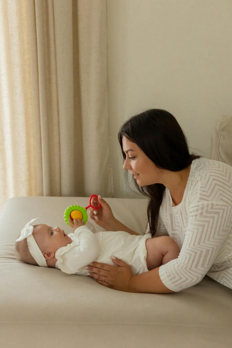 Mother playing with baby using colorful toy, fostering early development.